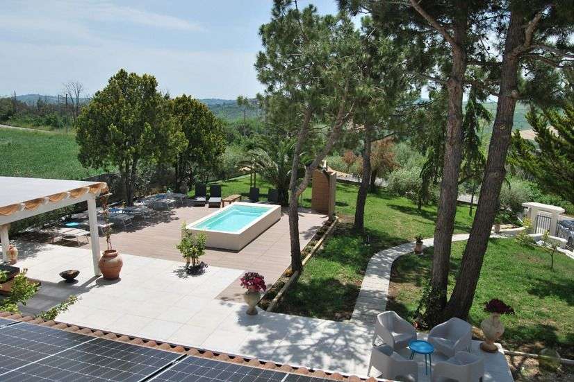 Eine Terrasse mit einem Swimmingpool und Sonnenkollektoren