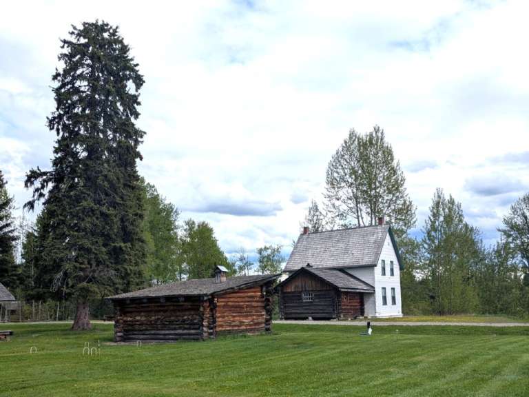 Ein kleines Holzhaus neben einem großen weißen Haus