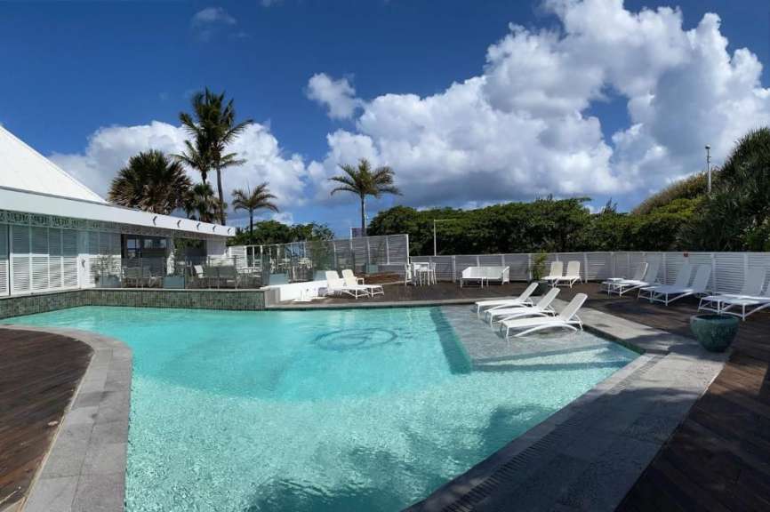 Ein großer Swimmingpool mit weißen Stühlen umgeben