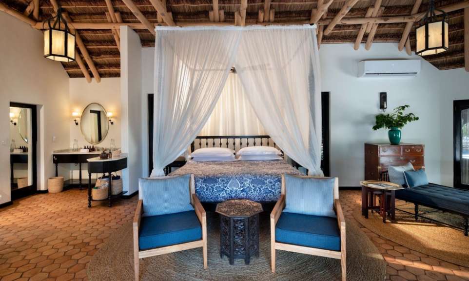 Ein Schlafzimmer mit einem Himmelbett und zwei Stühlen