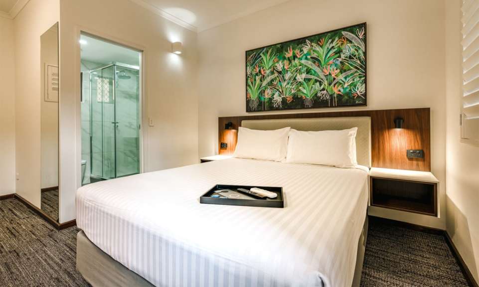 Ein Hotelzimmer mit einem Bett und einem Gemälde an der Wand