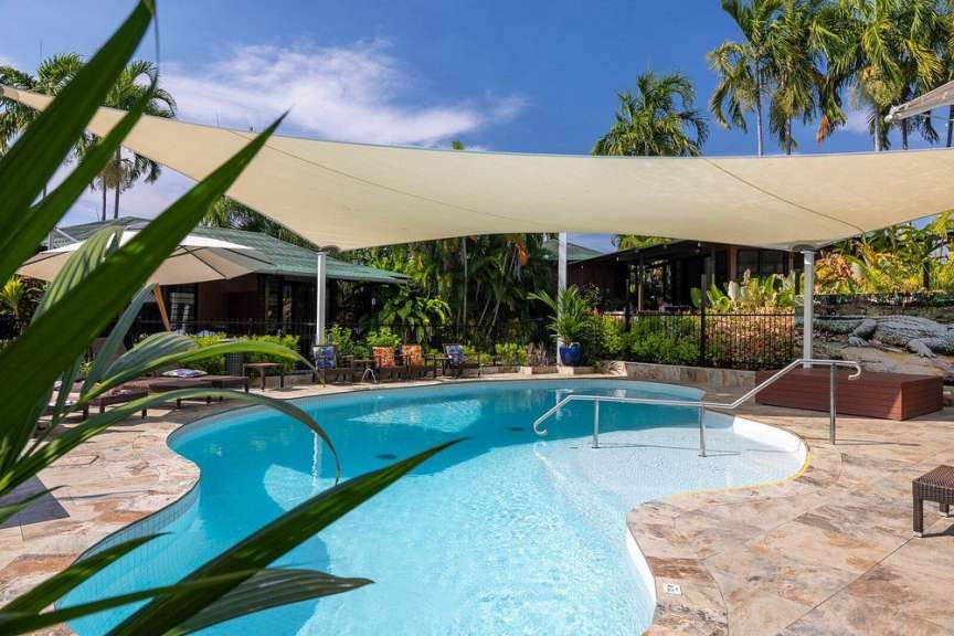 Ein großer Swimmingpool mit einem weißen Sonnenschirm darüber