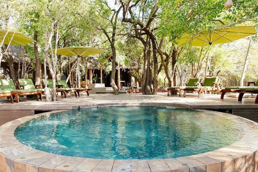 Ein großer Pool mit Liegestühlen und Sonnenschirmen umgeben