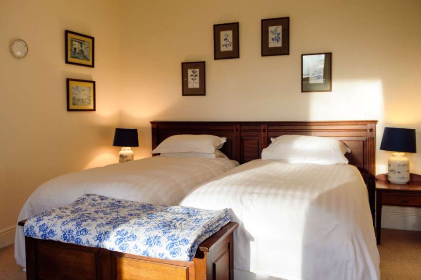 Ein Schlafzimmer mit zwei Betten und drei Bildern an der Wand
