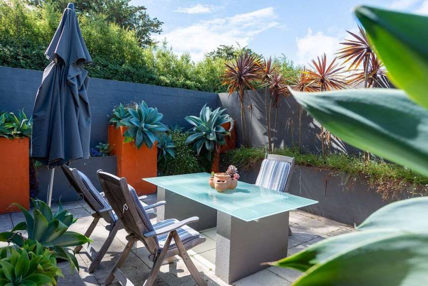 Ein Tisch mit Stühlen und Regenschirmen auf einer Terrasse