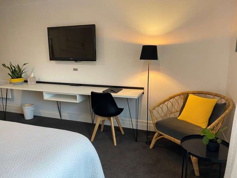 Ein Schlafzimmer mit einem Schreibtisch und einem Fernseher