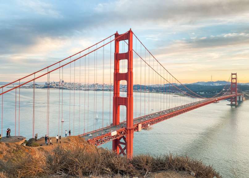 Eine Gruppe von Menschen steht auf einem Hügel mit Blick auf die Golden Gate Bridge