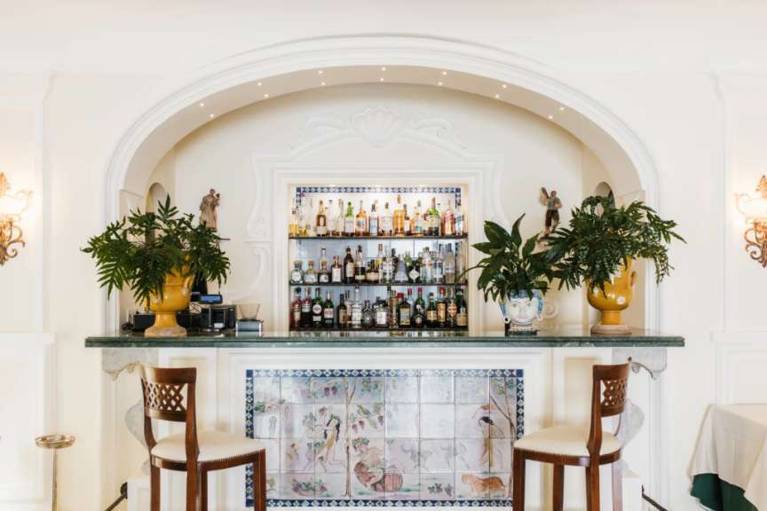 Eine Bar mit zwei Stühlen und einem Regal voller Flaschen
