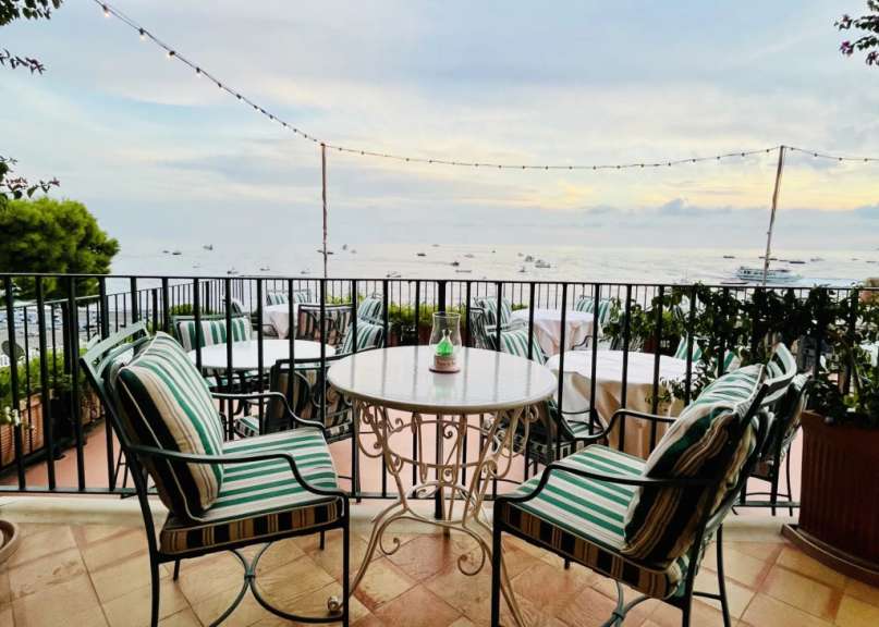 Ein Tisch und Stühle auf einem Balkon mit Blick auf das Meer