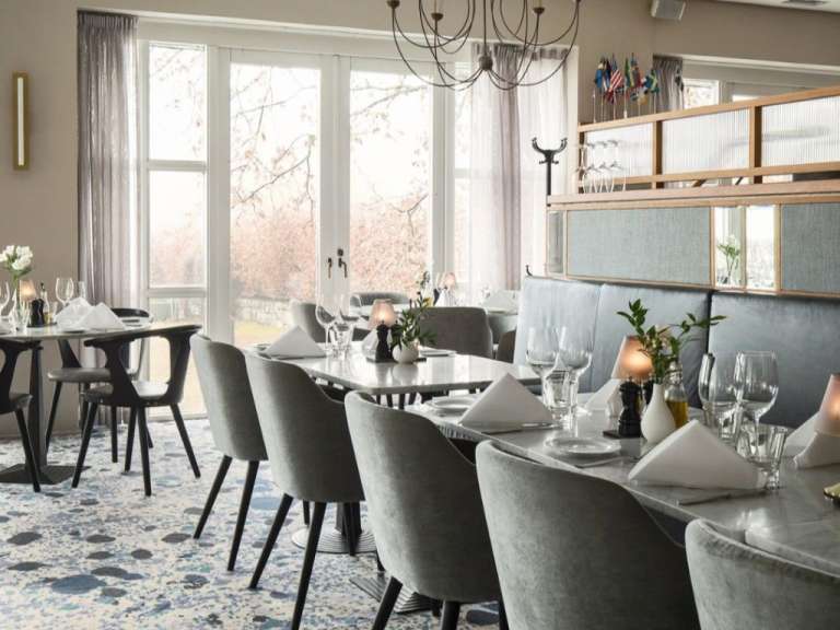 Ein Esszimmer mit vielen Tischen und Stühlen