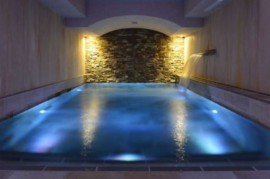 Ein Schwimmbad mit blauem Wasser und einem Wasserfall