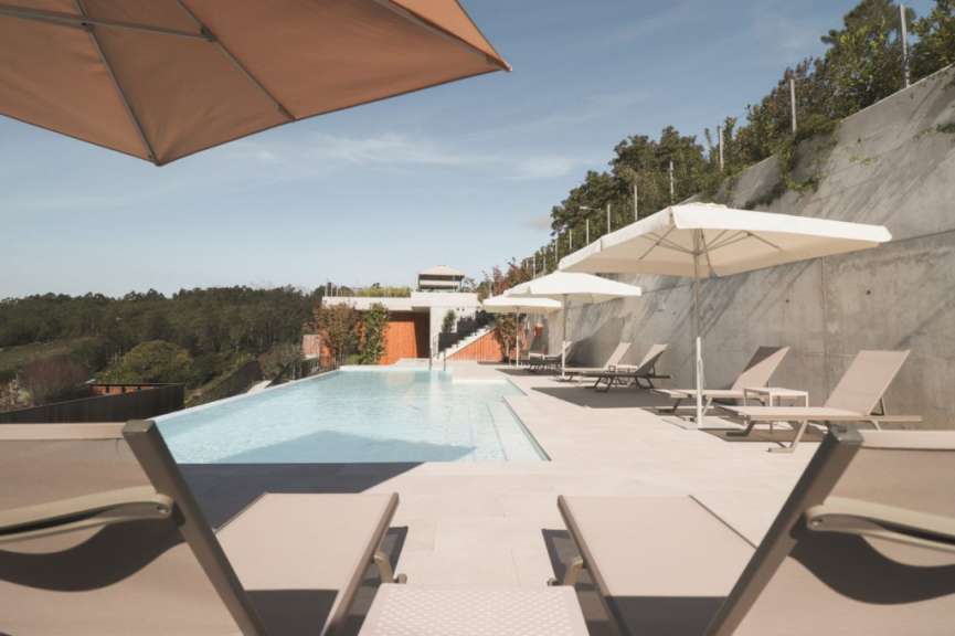 Liegestühle und Sonnenschirme umgeben einen großen Pool