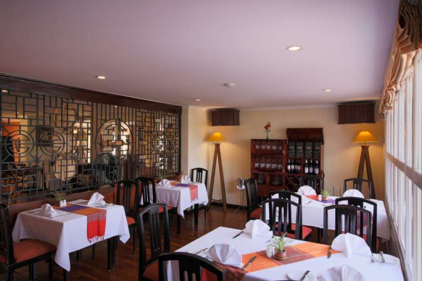 Ein Restaurant mit Tischen und Stühlen und einem Weinschrank