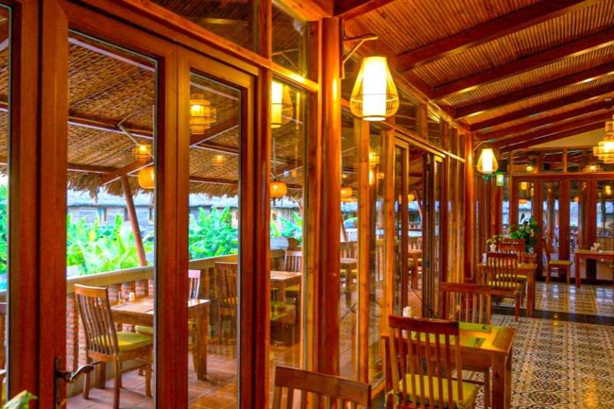 Ein Restaurant mit Tisch und Stühlen und vielen Fenstern
