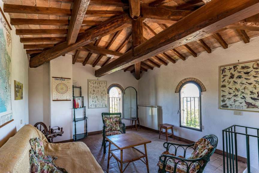 In diesem Bild wird ein gemütliches Wohnzimmer mit rustikaler Holzbalkendecke und traditionellen Möbeln gezeigt.
