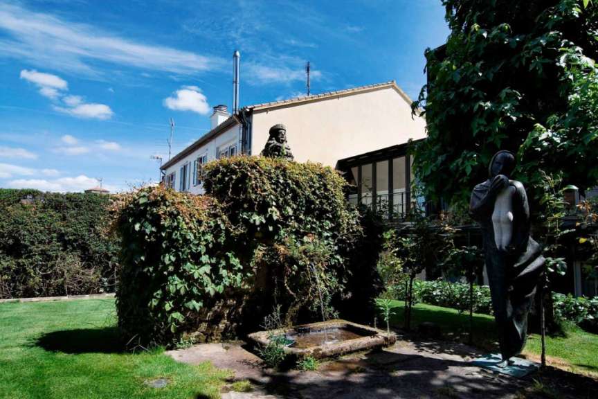 Eine Statue steht in einem Garten neben einem Brunnen