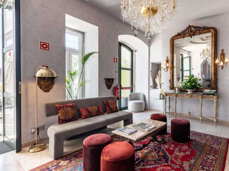 Ein prunkvoller Lobbysalon mit einem großen Spiegel, einer Couch und einem roten Teppich.