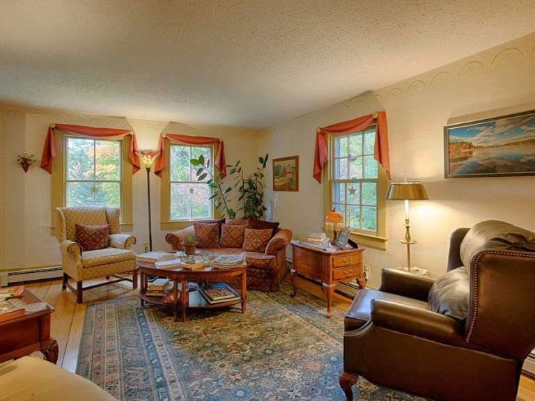 Ein Wohnzimmer mit Möbeln und einem Gemälde an der Wand