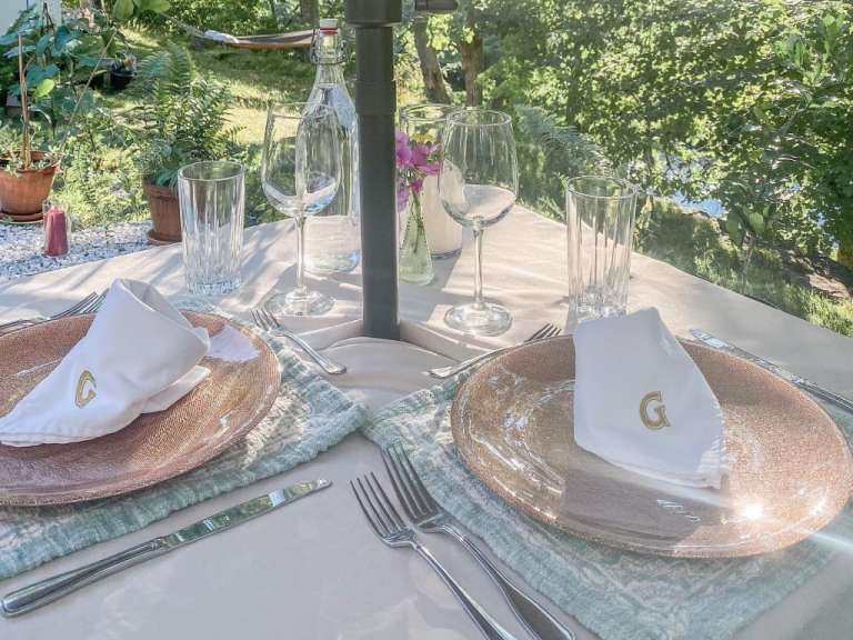 Ein Tisch mit Tellern und Gläsern und einem Geschirrtuch