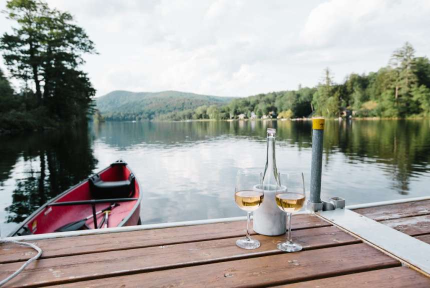 Zwei Gläser Wein stehen auf einem Dock neben einer Flasche Wein