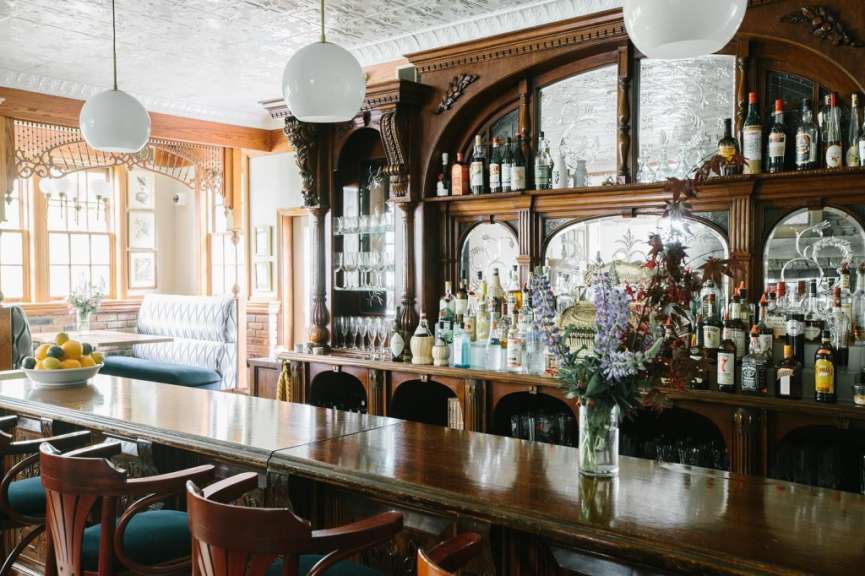 Eine Bar mit vielen Flaschen und einer Vase mit Blumen darauf