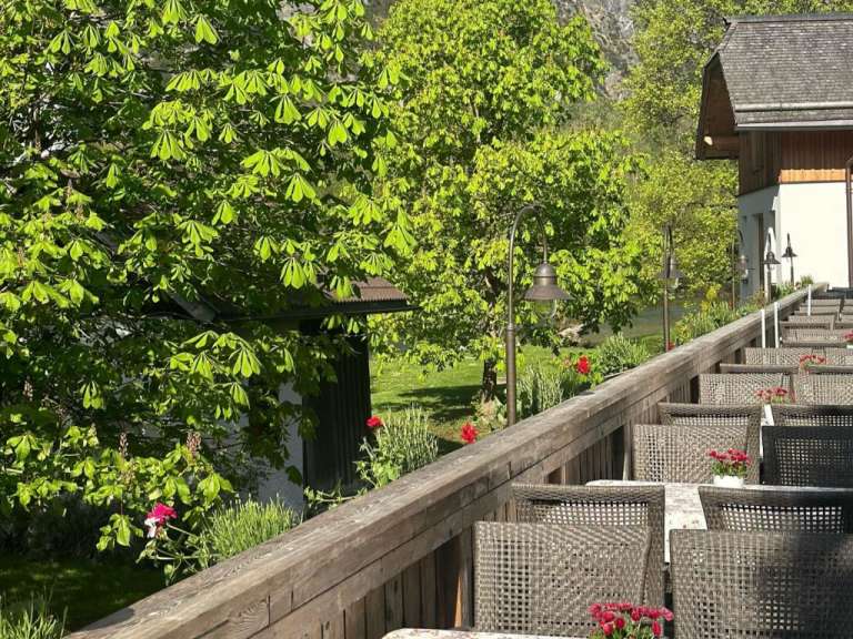 Eine Reihe von Stühlen und Tischen auf einem Holzdeck