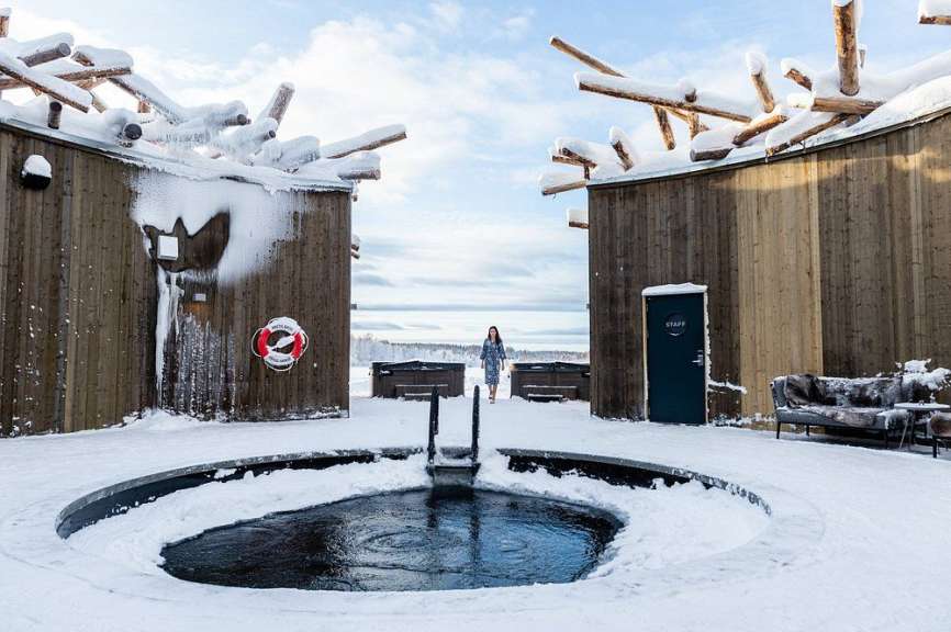 Eine Frau geht an einem schneebedeckten Pool vorbei