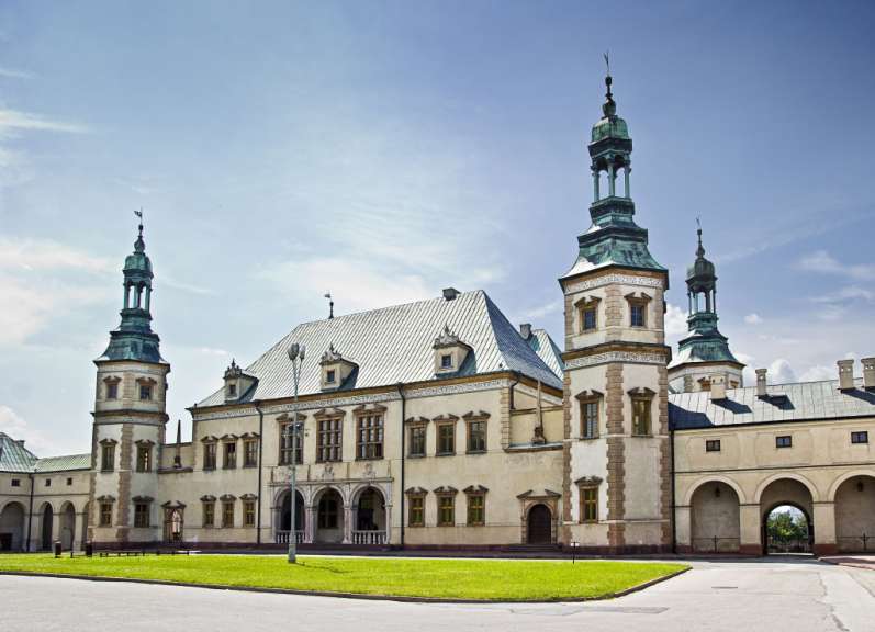 Ein Palast mit mehreren Türmen und einer gepflegten Rasenfläche davor ist unter einem blauen Himmel zu sehen.