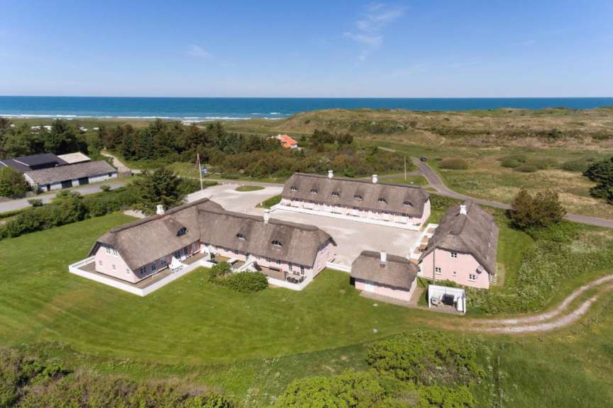 Eine Gruppe von Reetdachhäusern mit Blick auf das Meer