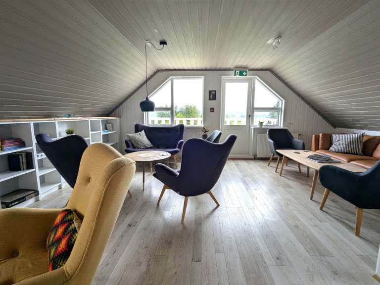 Ein Wohnzimmer mit vielen Stühlen und einem Tisch