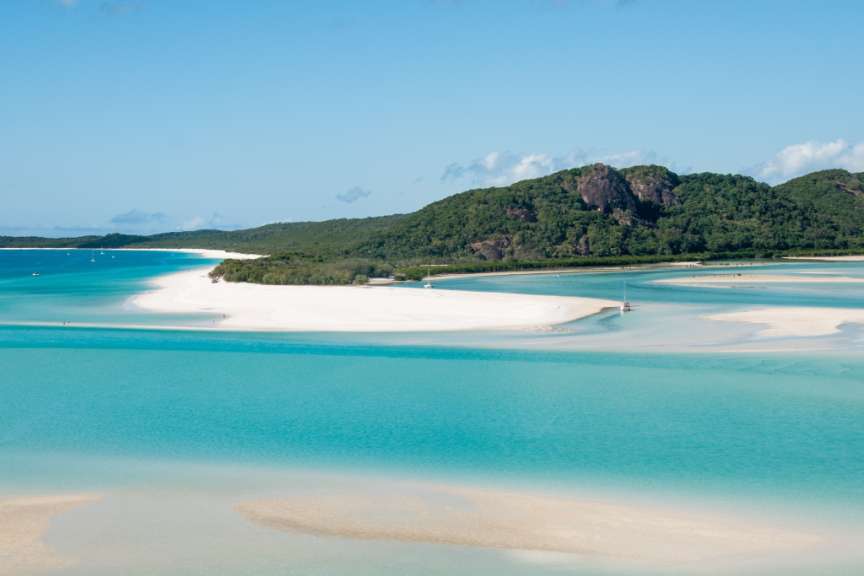 Ein Strand mit weißem Sand und türkisfarbenem Wasser