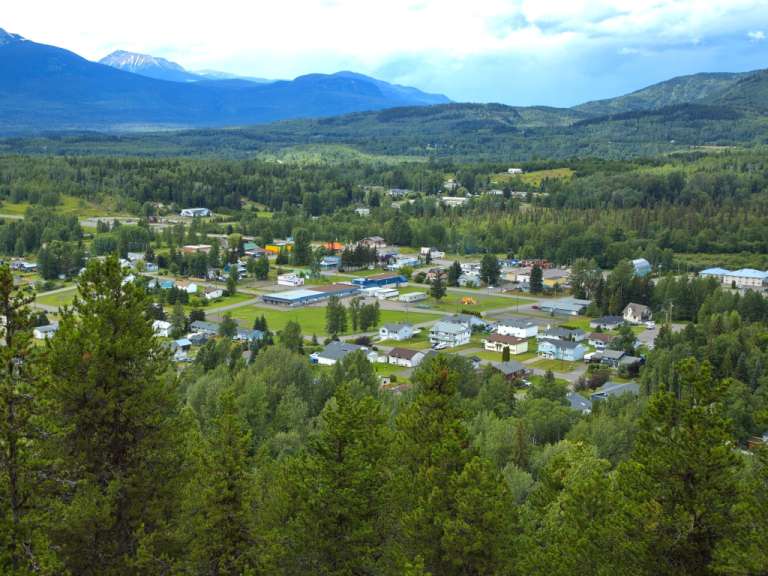 Eine kleine Stadt liegt inmitten einer grünen Landschaft mit Bergen im Hintergrund