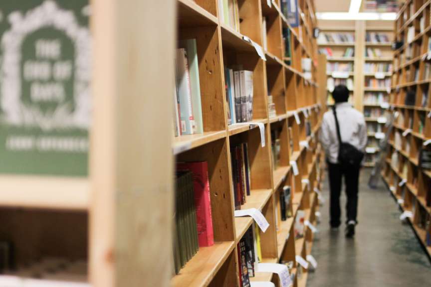 Ein Mann geht in einem Buchladen und schaut sich die Bücher an