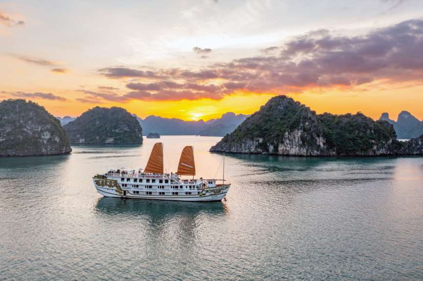 Ein großes weißes Boot schwimmt in einem See bei Sonnenuntergang