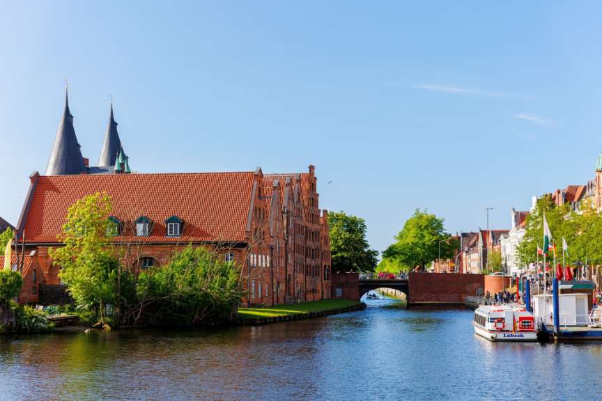 Ein kleines rot-weißes Boot fährt durch einen Fluss