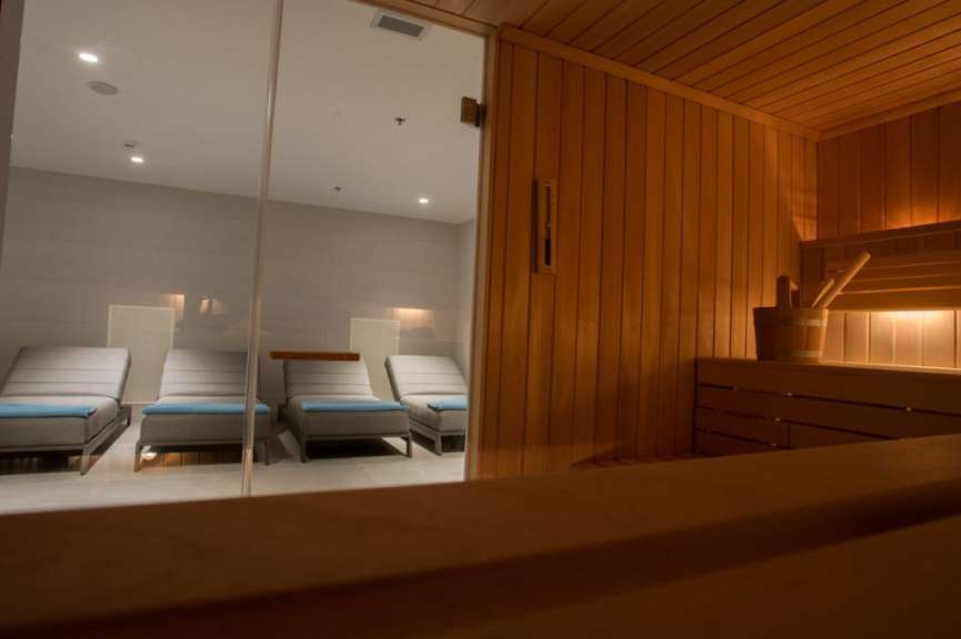 Eine Holzsauna mit Liegestühlen und einem Eimer