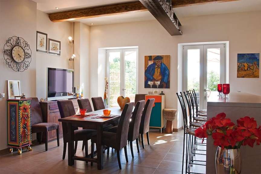 Ein Esszimmer mit einem Tisch und Stühlen und einer Uhr an der Wand