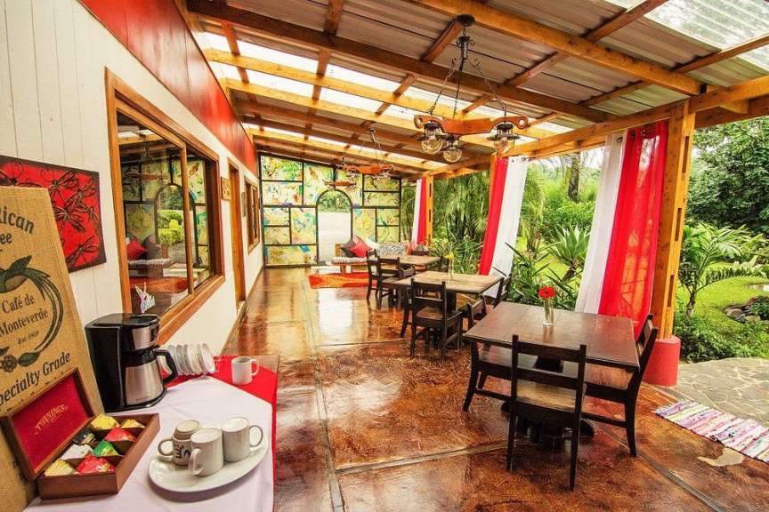 Ein Tisch mit Tassen und einer Kaffeemaschine neben einem Zeichen, das sagt „ cafe de monteverde “