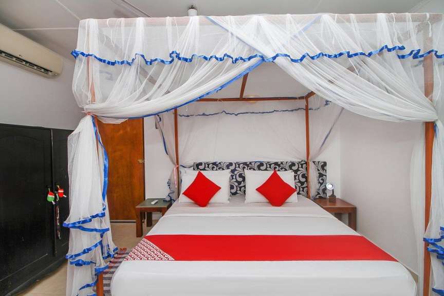 Ein Schlafzimmer mit Himmelbett und roten Kissen
