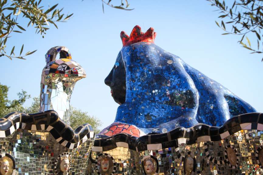 Eine blaue Skulptur mit einer roten krone auf dem Kopf
