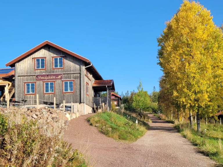Ein braunes Holzhaus mit einem Schild an der Seite, das sagt ' fredsgården '