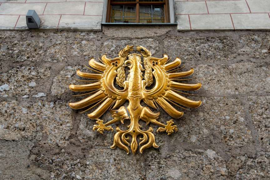 Ein goldenes Wappen an der Seite eines Gebäudes