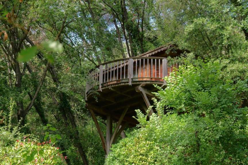 Ein Baumhaus mit einem Balkon im Wald