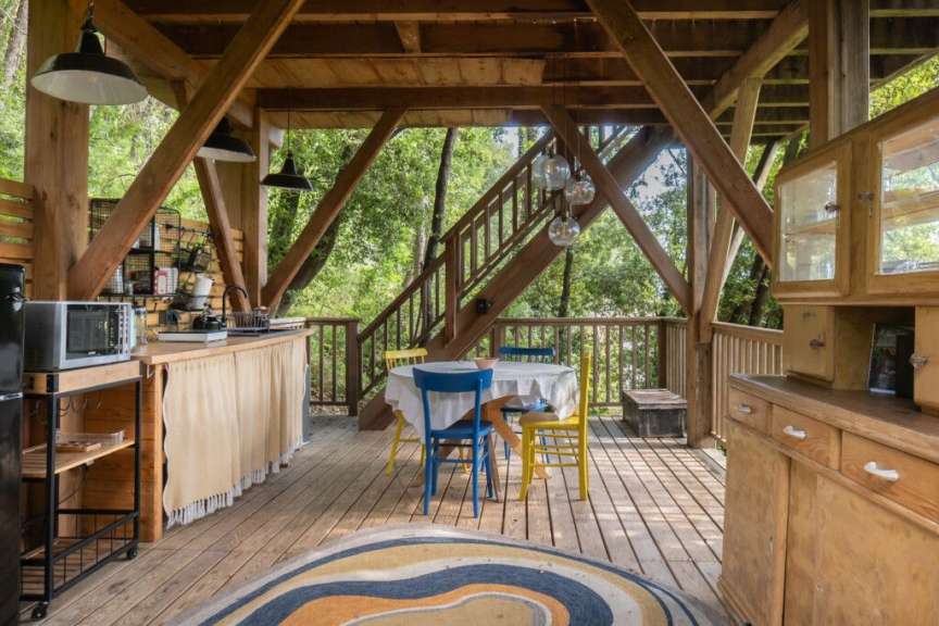 Eine Küche mit einem Tisch und Stühlen auf einem Deck