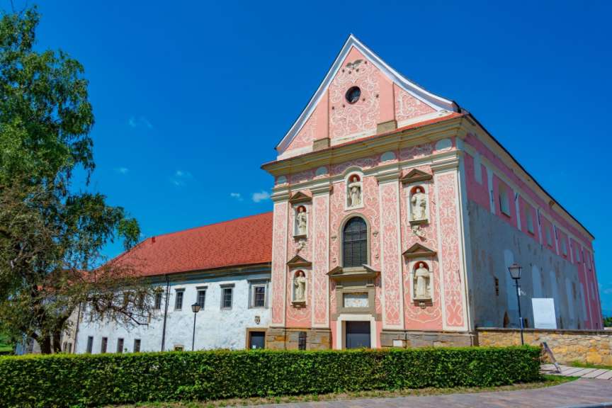 Ein rosa und weißes Gebäude mit vielen Statuen darauf