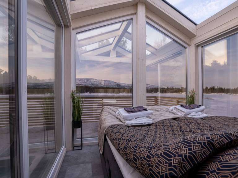 Ein Schlafzimmer mit einem Bett und vielen Fenstern