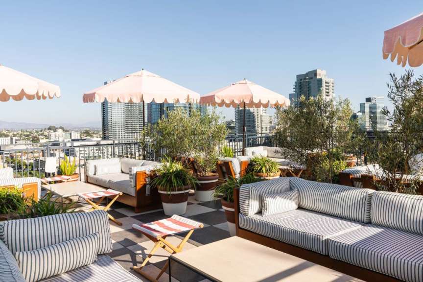 Eine Terrasse mit Möbeln und Regenschirmen mit Blick auf die Stadt