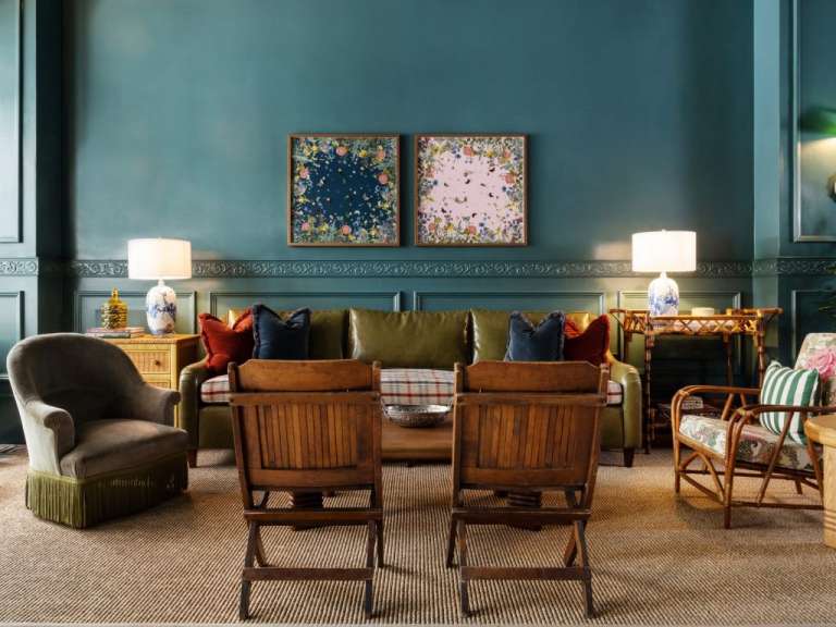 Ein Wohnzimmer mit einem grünen Couch und zwei Bildern an der Wand