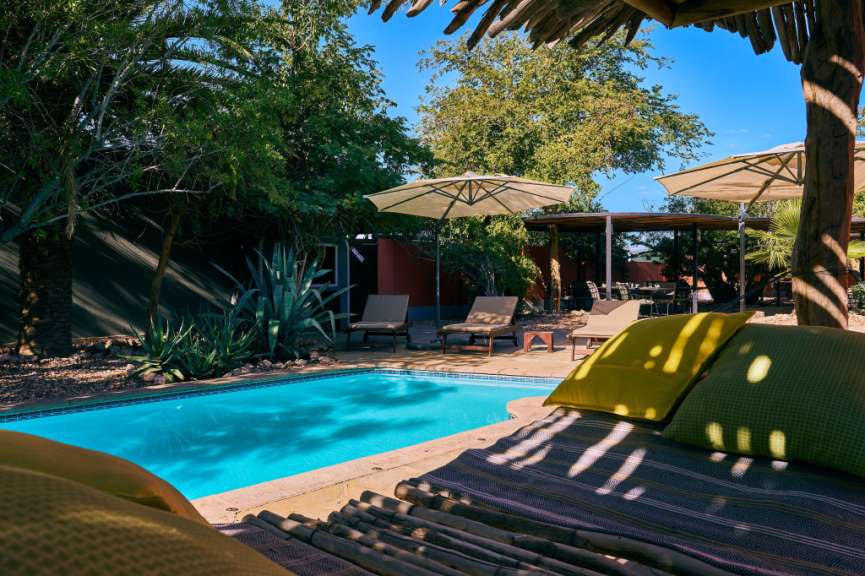 Ein Swimmingpool mit Liegestühlen und Sonnenschirmen umgeben