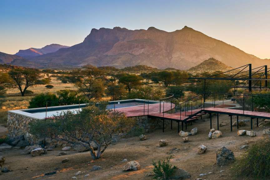 Ein Haus mit einem Pool und einem Berg im Hintergrund